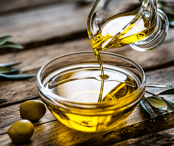 olive oil being poured into bowl showing benefits of olive oil for dry, aging, crepey, damaged, sensitive skin